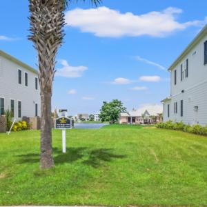 View of grassy yard with an attached garage and dr