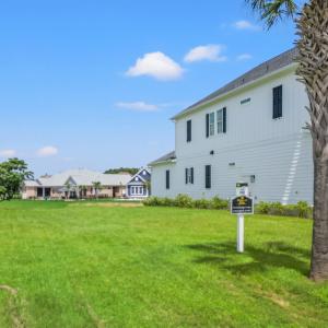 View of green lawn featuring an attached garage an