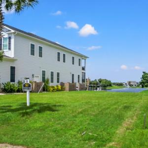 View of grassy yard featuring a water view, concre