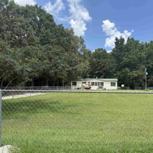Fenced backyard featuring a forest view