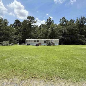 View of front facade with a front yard and a fores