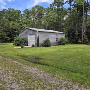 View of grassy yard with an outbuilding and a gara