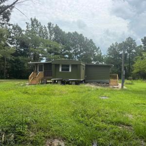 Rear view of house with view of wooded area, a law