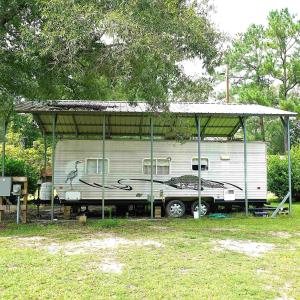 View of parking / parking lot with a carport and v