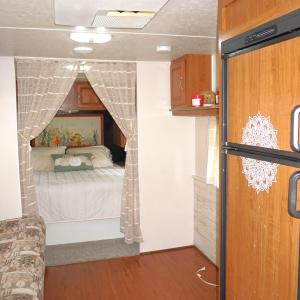 Bedroom with paneled fridge and wood finished floo