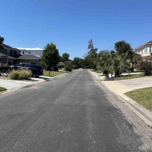 View of asphalt street with curbs and a residentia