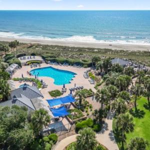Aerial view of a pool area and waterfront with a b