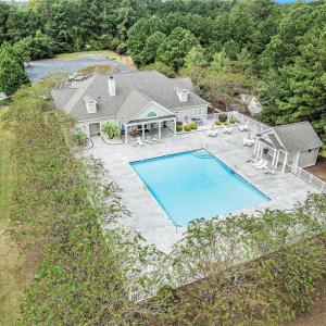 Community pool with a patio area and a wooded view