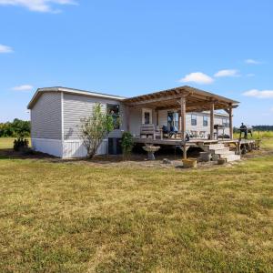 Back of property featuring a lawn and a wooden dec