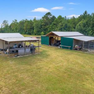 View of grassy yard with a pole building, an outbu