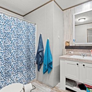 Full bathroom with a textured ceiling, vanity, lig