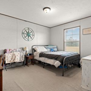 Bedroom with light colored carpet, a textured ceil