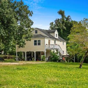 Back of house with stairway, a yard, a wooden deck