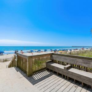 Deck with view of water and beach