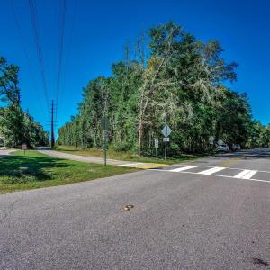 View of asphalt road featuring traffic signs and v