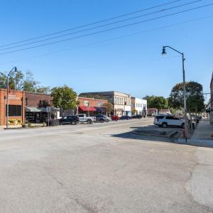 View of asphalt road with street lights, sidewalks