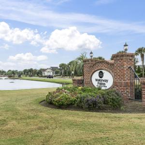 Community sign with a lawn and a water view