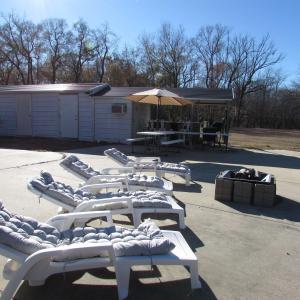 Large patio area with loungers, firepit and buildi