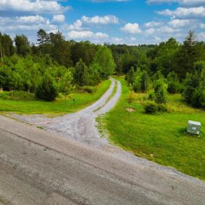 View from Two Bid Road down gravel drive that cuts across the property.