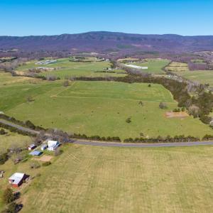 East Point Road frontage looking northwest.  In view is the grazing pasture with pond, and hay pasture just beyond.