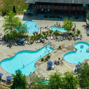 The expansive main recreation area by the General Store generally features three distinct water sections: a main swimming pool, a designated activity/kiddie pool, and an interactive splash pad for children.