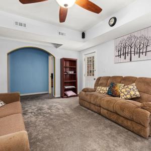 Family room downstairs. To the right of the blue wall is Bedroom 5. to the left is another full bath, a large storage room, and what another flex room with a closet but no window.