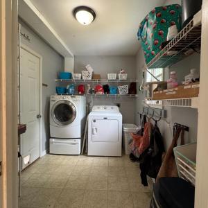 Laundry room with hooks for backpacks and shelves behind the door on left also. The door to the garage is here on the left.