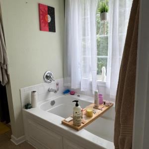 Add a tub with a window to relax enjoy a bath with a pretty view of trees.