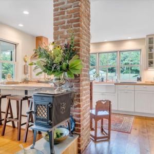 Jøtul “Little Giant” woodstove with glass door. Exposed original chimneys … mantels frame upstairs bedroom windows.