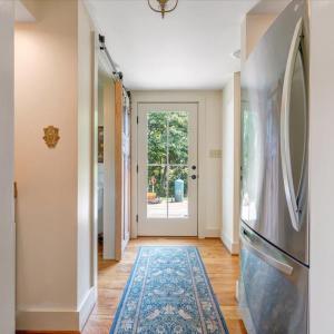 Refrigerator is inset within the hallway, conveniently adjoining the kitchen.