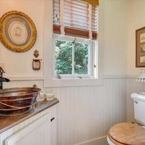 Copper bowl sink. Mirror original to house. “Appointments” found around property and brought in as “museum pieces”.