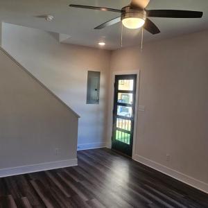 Living room showing 5 lite glass front door , stairs to 2nd floor and vinyl plank flooring