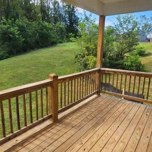 Covered rear deck overlooks greenspace area
