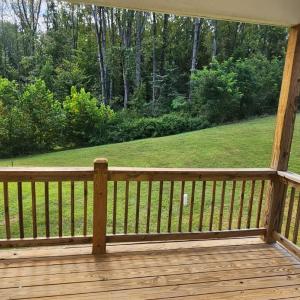 Covered rear deck overlooks greenspace area