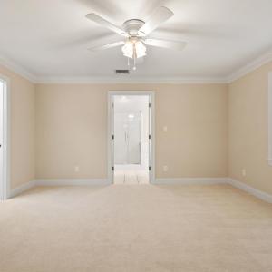 Large sitting room with walk-in closet to left and primary bathroom straight ahead