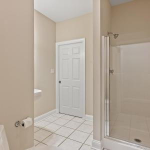 Full bathroom entry from garage and pocket door leads to office/future main level bedroom
