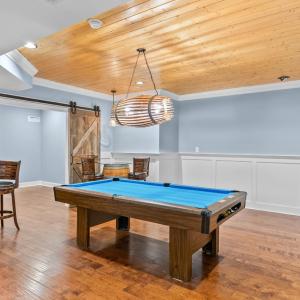 Pool table area and dart board looking into another game room or guest room