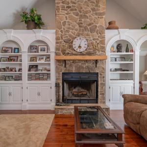 Great room w/ 14 ft ceiling, built in arched shelving & cabinets on both sides of rock FP, open to kitchen