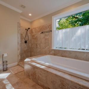 Primary bath with ceramic tile shower walls, jetted tub w/ ceramic tile surround , ceramic tile floors , double sink vanity, 2 built in linen cabinets