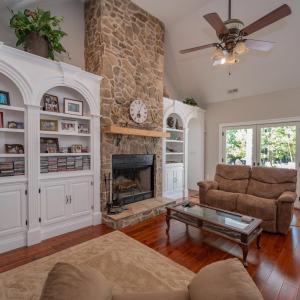 Greatroomshowing French door to deck, rock FP, arched built in display  shelves and cabinets