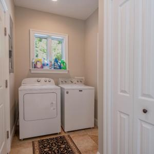 Laundry room in hallway from kitchen as well as half bath to right
