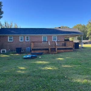 Deck built in 2024 leads out to level fenced backyard.