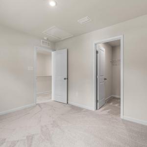 Bedroom 2 opposite Primary suite on the front of the house. The closet is a large lighted L-shqped walk in