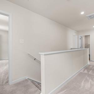 At the top of the stairs is the Primary suite.  The large linen closet is pictured here at the end of the hall.