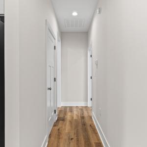 Hallway to Primary suite on right, large laundry room to left