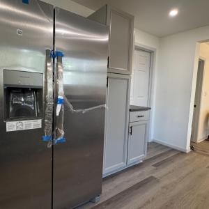 Lots of cabinets and great lighting! Left of the frig is the laundry room. The door on the right is the dowstairs full bath. Just past this wall is the door to the downstairs bedroom