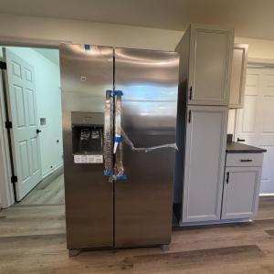 The refrigerator is on the opposite side from the sink. The laundry room on the left. The downstairs bathroom on the right