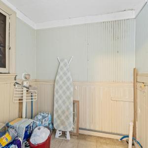 Main floor laundry room with original beadboard. At bottom right, see electric and plumbing leading to a room on the other side of the wall on the exterior