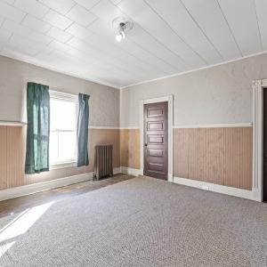 Bedroom 1 at the front of the hosue. The door by the window is a pass through to the room behind it on the back of the house. the door on the right is the closet.