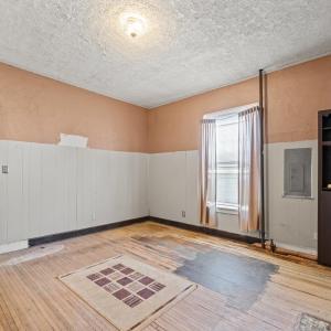 The Dining room with a peek at the kitchen on the left. This patch of (darker) floor was not refinished when the floors were done.There are two closets  on the back side wall.